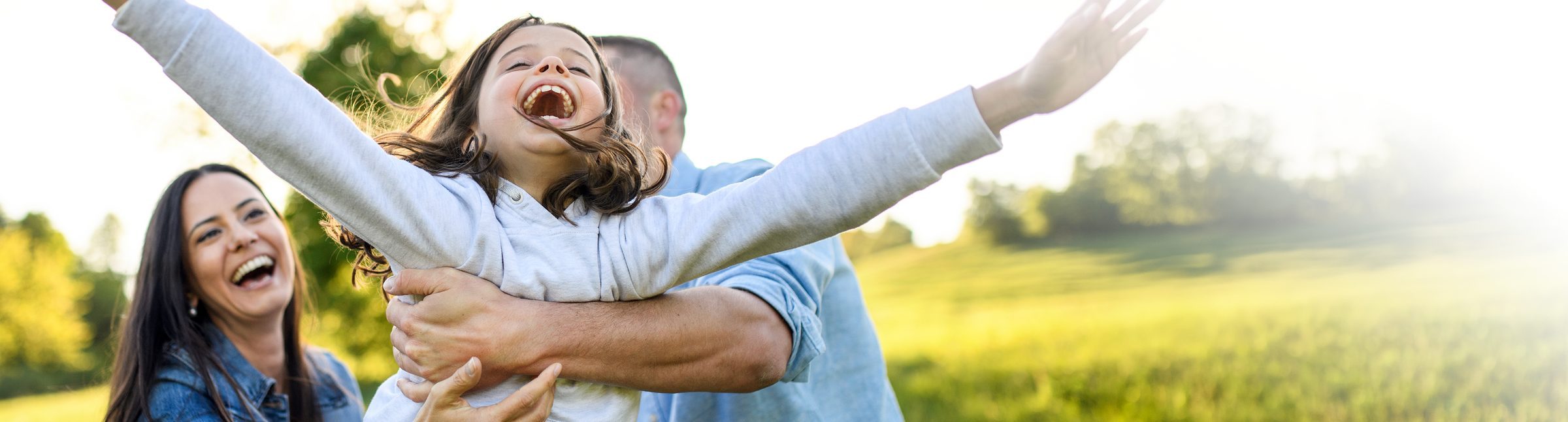 Happy family with their young daughter having fun outdoors